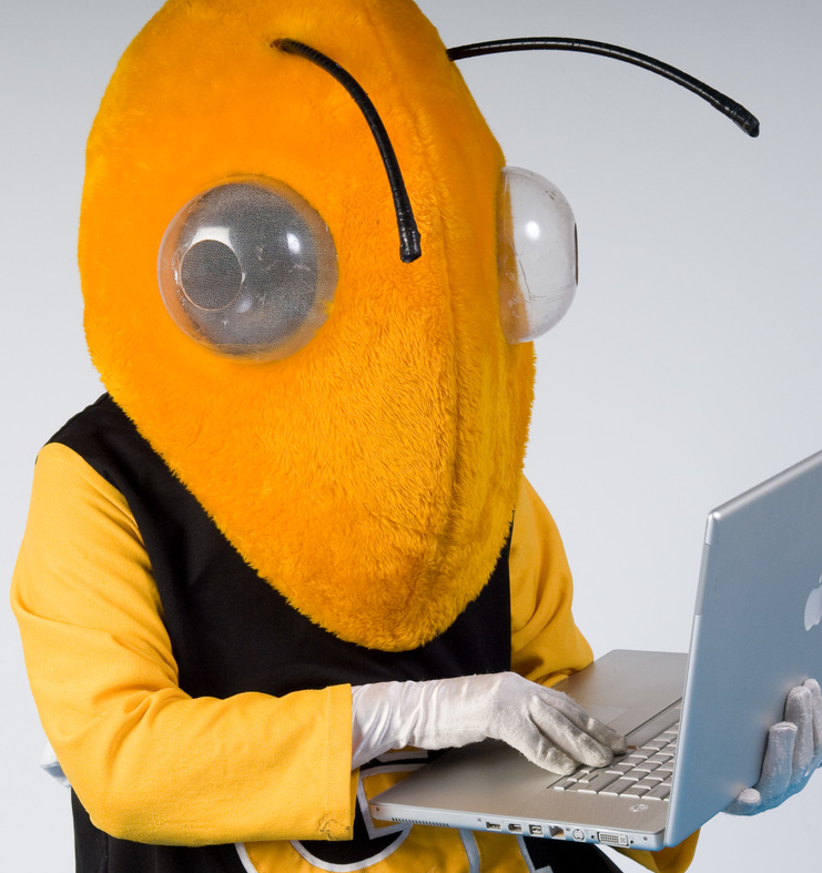 Buzz mascot holding a laptop.