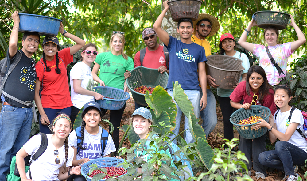 A group of mentors and students during a service trip in Guatemala. They're visiting a coffee farm.