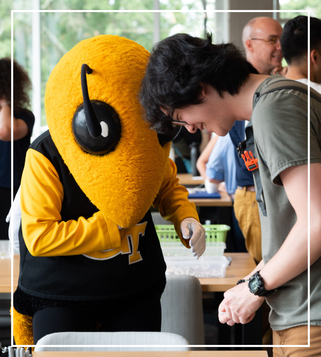 Buzz helps a student leader create a "My Name Is...." Style Nametag at the Big Buzz Student Leader Mixer.
