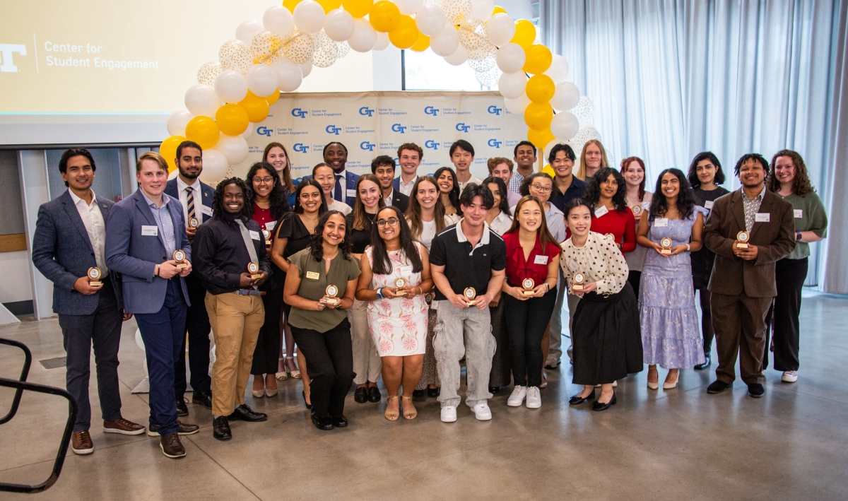 2025 honorees standing together in front of balloons and banner